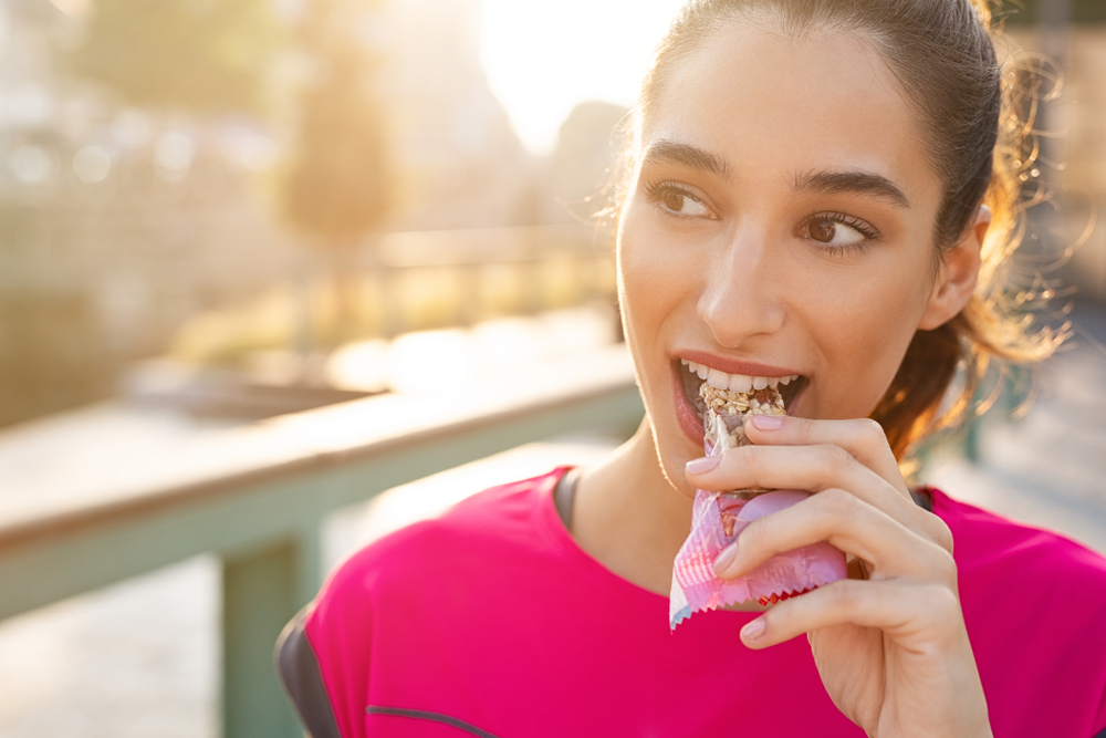 a woman eating a granola bar
