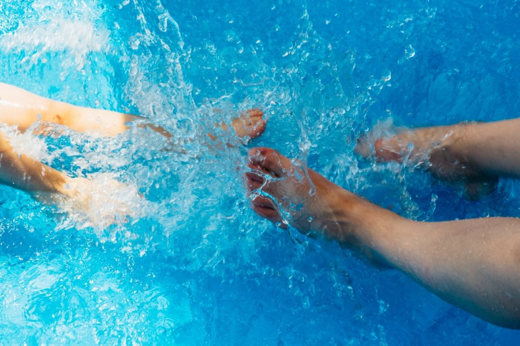 two pairs of feet in the pool | ways to cool off in apartment