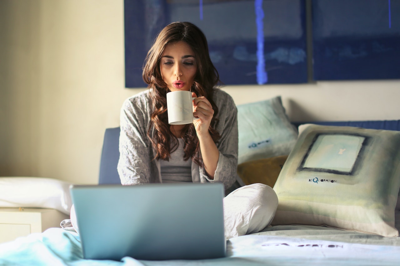 blowing on coffee while working in bed | tips on setting up a work-from-home space