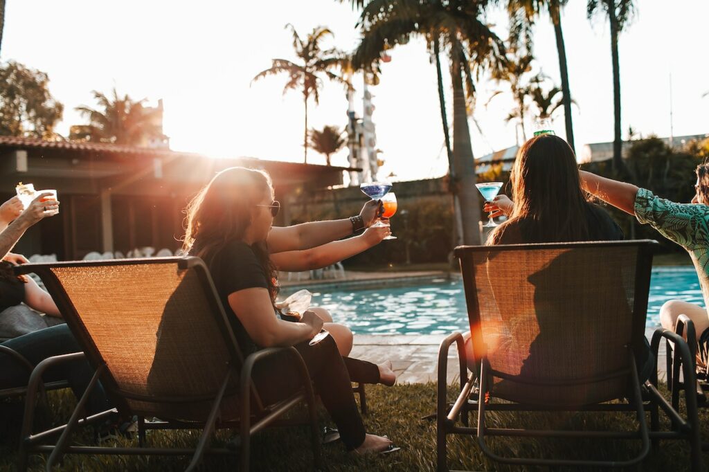 friends having drinks by the pool | must-haves for a community barbecue